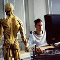 Keen employee sat at a computer, with a realistic human model in shot